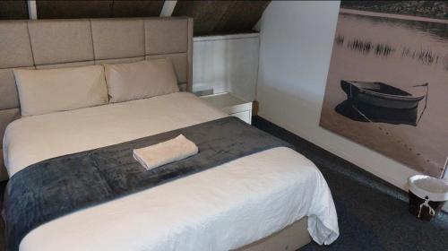a bedroom with a bed with a picture of a boat at Gallery Guesthouse (La Sky Villa) in Gqeberha