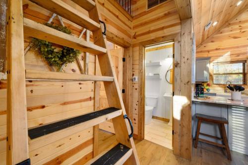 a tiny house with a staircase in a kitchen at Twilight Pines - Dreamy Cabin w Hot Tub & optional Kids Loft in Broken Bow