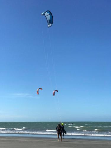 two people are flying a kite on the beach at Pousada Canaã Icaraizinho in Amontada