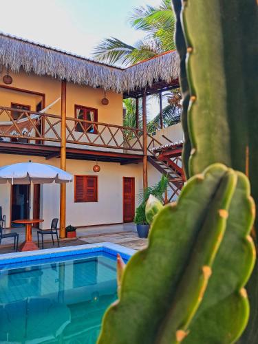 a house with a swimming pool and a cactus at Pousada Canaã Icaraizinho in Amontada