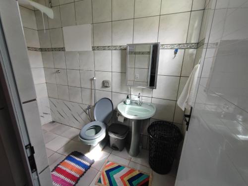 a small bathroom with a toilet and a sink at Quarto Califórnia in Campo Novo do Parecis