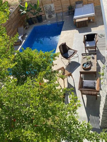 a backyard with a pool with chairs and a table at Peaceful Holiday Villas-Pomegranate-3 bathrooms-Private pool in Belek
