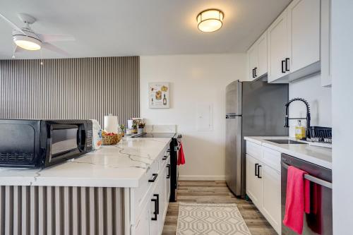 a kitchen with white cabinets and a stainless steel refrigerator at Ocean View, Community Perks Makaha Valley Condo! in Waianae
