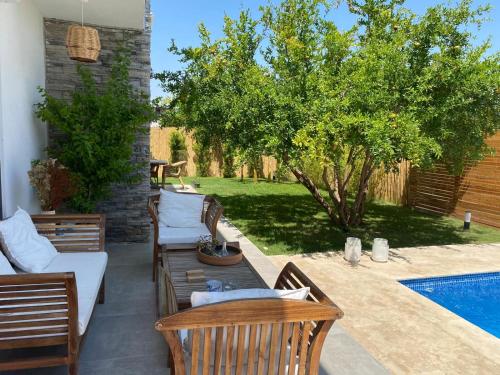 a patio with chairs and a table next to a pool at Peaceful Holiday Villas-Pomegranate-3 bathrooms-Private pool in Belek
