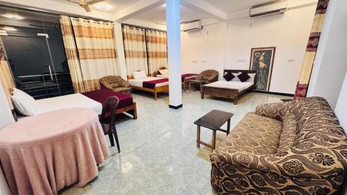 a living room with a couch and chairs in a room at The Hideaway Haven in Trincomalee