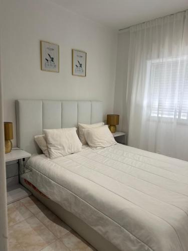 a white bed in a bedroom with a window at Luxury home in Amora