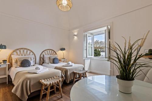 a bedroom with two beds and a table at Lavradores Boutique Guesthouse in Évora