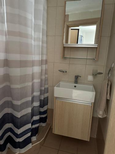a bathroom with a sink and a shower curtain at Studio Green Patio in Hanioti