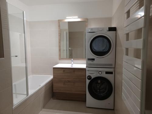 La salle de bains est pourvue d'un lave-linge et d'un miroir. dans l'établissement T2 neuf 2024, terrasse, parking, RER B et VAL à 2 pas, à Antony
