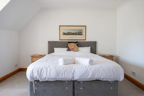 a bedroom with a large bed with two pillows at Old Distillery Lodge in Kingussie