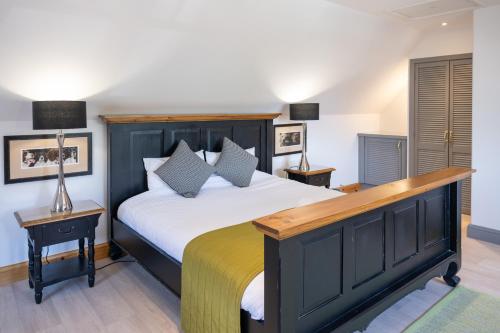 a bedroom with a large bed and two lamps at Old Distillery Lodge in Kingussie