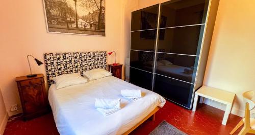 une chambre avec un lit blanc dans une pièce dans l'établissement AC - Hypercenter - Quiet with a view!, à Avignon