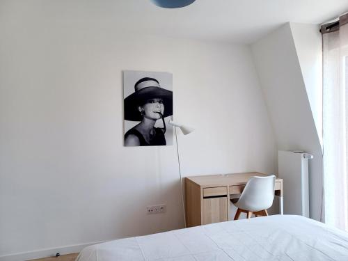 une chambre avec une photo en noir et blanc d'une femme portant un chapeau dans l'établissement T2 neuf 2024, terrasse, parking, RER B et VAL à 2 pas, à Antony