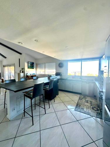 une grande cuisine avec une table et des chaises. dans l'établissement Duplex 6 personnes 140m2, à Perpignan