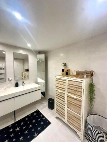 une salle de bain avec un lavabo et un miroir dans l'établissement Duplex 6 personnes 140m2, à Perpignan