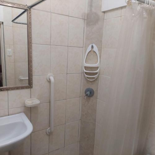 a bathroom with a shower with a sink and a mirror at Hotel Almond Beach in Tonsupa