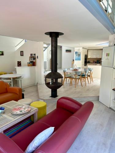ein Wohnzimmer mit einem roten Sofa und einem Kamin in der Unterkunft Modern Villa High Standing Pyla sur Mer 3' from beach in Pyla-sur-Mer