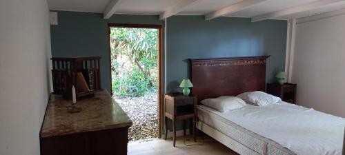 une chambre avec un lit et une porte donnant sur une cour dans l'établissement Maison de vacances de famille sous les pins, à Gujan-Mestras