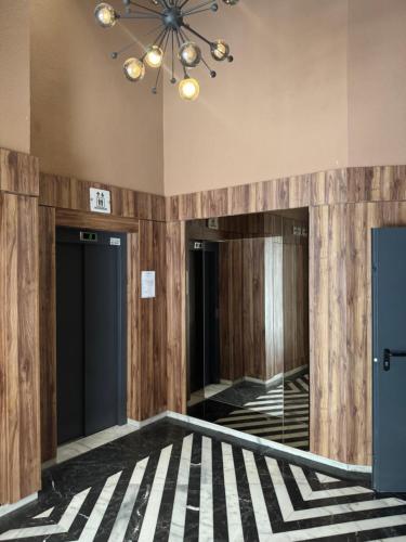a hallway with wooden walls and a ceiling with a chandelier at Appartement au parc à 3 minutes de la plage in Mohammedia