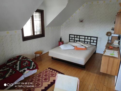 a small bedroom with a bed and a window at Guest House Veliki Grabovski in Grab