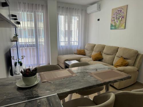 a living room with a table and a couch at Orkidea Apartments in Golem