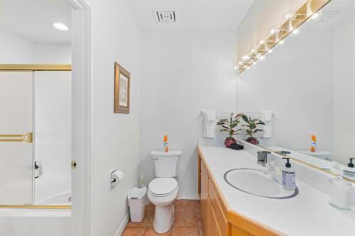 a white bathroom with a toilet and a sink at Frosty Summit Condo at Mount Bachelor Village Resort with Pool and Hot Tub in Bend