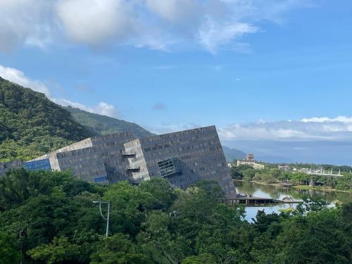 a building on a hill with a river and trees at Blue Sea and Sunny B&B in Toucheng