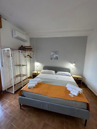 a bedroom with a bed with two towels on it at Il Villaggio Hotel Residence Lì Cylentos Elios a 100 mt dal mare cilentomarexperience in Policastro Bussentino