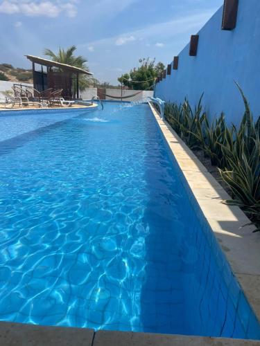 a blue swimming pool with a blue wall at Paradise Beach in Fortim