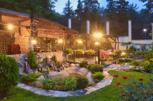 a garden in front of a building with a fountain at Villa Vodno in Skopje