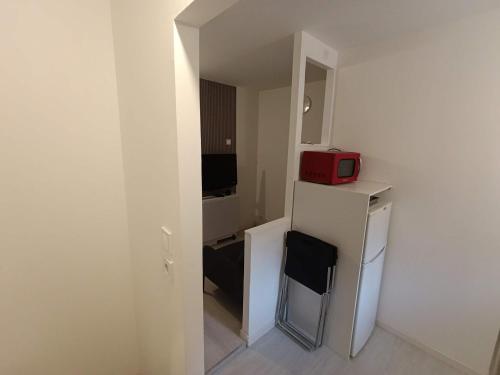 une petite pièce blanche avec un réfrigérateur et un micro-ondes rouge dans l'établissement Charmant petit duplex en Provence, à Cabasse