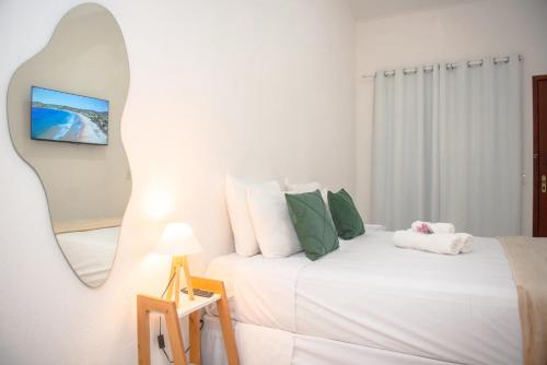 Pousada vila Riveira في بوزيوس: غرفة نوم بها سريرين ومرآة