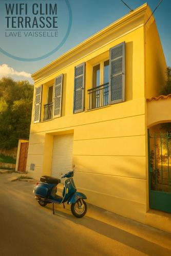 un scooter garé devant une maison jaune dans l'établissement La 34 Tiny House with sunny terrace, à Menton