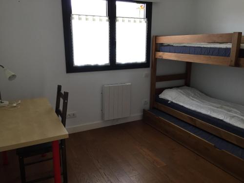 une chambre avec deux lits superposés et un bureau dans l'établissement Evasion à la montagne, à Saillagouse