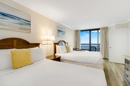 a hotel room with two beds and a balcony at Impressive 1Br Oceanfront Suite, Dogs OK! 1006 in Myrtle Beach