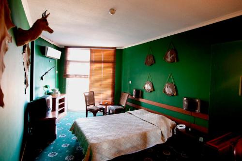 a bedroom with green walls and a bed with a deer head on the wall at Sylva Hotel in Limassol