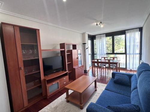 a living room with a blue couch and a tv at Soto de la Marina apartamento cerca playa in Soto de la Marina