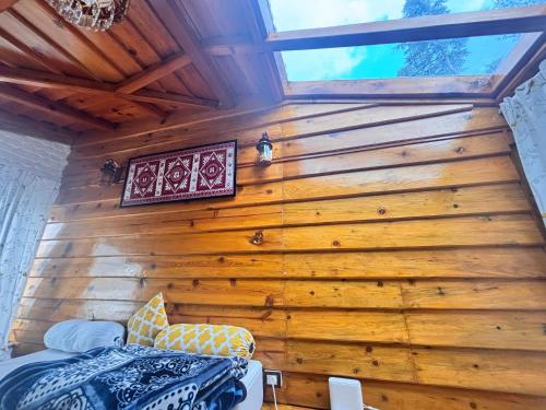 a bedroom in a tree house with wooden walls at Panchwati Farms Homestay in Almora
