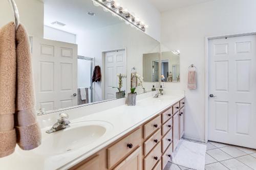 a bathroom with a sink and a large mirror at Resort-Style Amenities at Palm Desert Getaway in Palm Desert