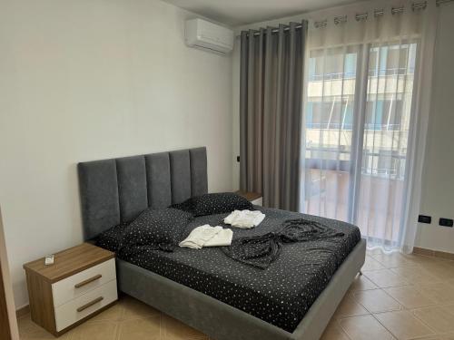 a bedroom with a bed with a headboard and a window at Orkidea Apartments in Golem