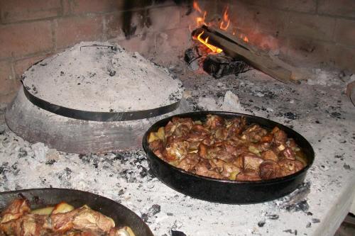 two pans of food are cooking on a stove at Agrotourism Matusko in Neum