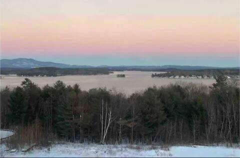 a view of a body of water at sunset at Lake Winni Studio Condo Full Kitchen - Weirs Beach in Laconia