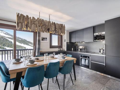 une cuisine avec une table en bois et des chaises bleues dans l'établissement Appartement 4 adultes-2 enfants, proche pistes, 3 ch, cheminée, parking, Courchevel Moriond - FR-1-563-147, à Courchevel