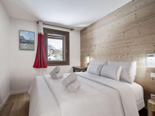 - une chambre avec un grand lit blanc et un mur en bois dans l'établissement Appartement 4 adultes-2 enfants, proche pistes, 3 ch, cheminée, parking, Courchevel Moriond - FR-1-563-147, à Courchevel