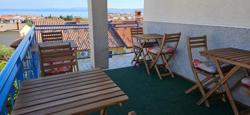 two tables and chairs on a balcony with a view at Rooms Laguna Maresol in Jagodje