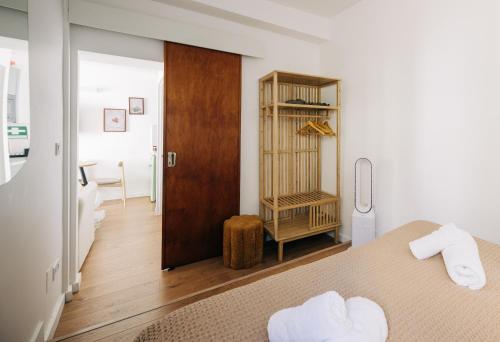 1 Schlafzimmer mit 2 Betten und einer Holztür in der Unterkunft Octopus House Caparica in Costa da Caparica