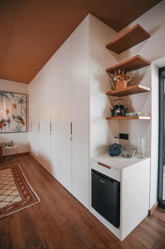 a kitchen with white cabinets and a black dishwasher at Casa da Veiga de Ponte de Lima in Ponte de Lima
