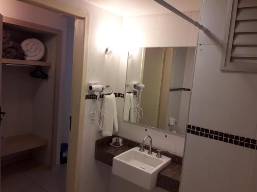 a bathroom with a sink and a mirror at SJ Tour - San Juan Foz do Iguaçu in Foz do Iguaçu