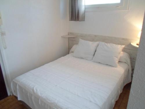 - un lit blanc avec des draps et des oreillers blancs dans l'établissement Confort 22m² ✅WIFI, Animaux admis, Près des Thermes - FR-1-503-22, à Balaruc-les-Bains