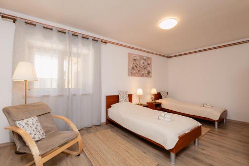 a bedroom with two beds and a chair in it at Kuća za odmor Roko in Sveti Rok